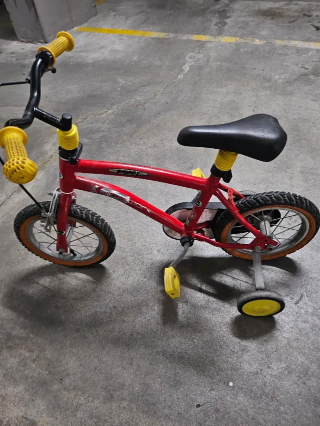 Bicicleta infantil roja con ruedines
