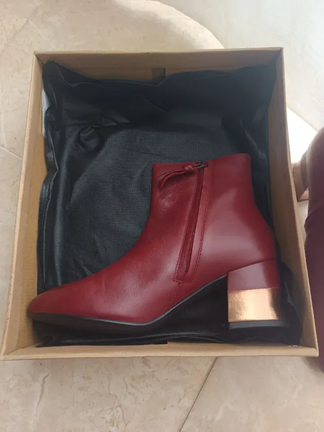 Botines Gioseppo burdeos con tacón dorado.