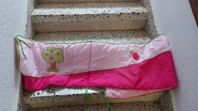 Ropa de cuna rosa con abeja.