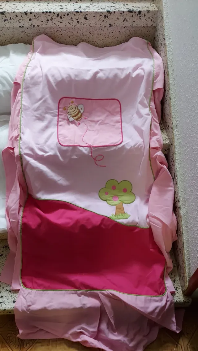 Ropa de cuna rosa con abeja.
