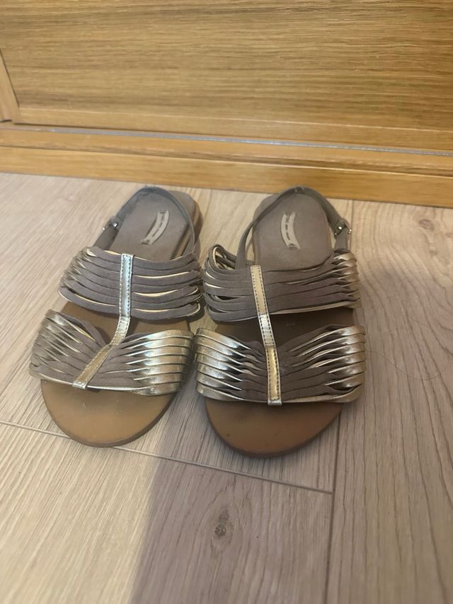 Sandalias planas doradas y marrones