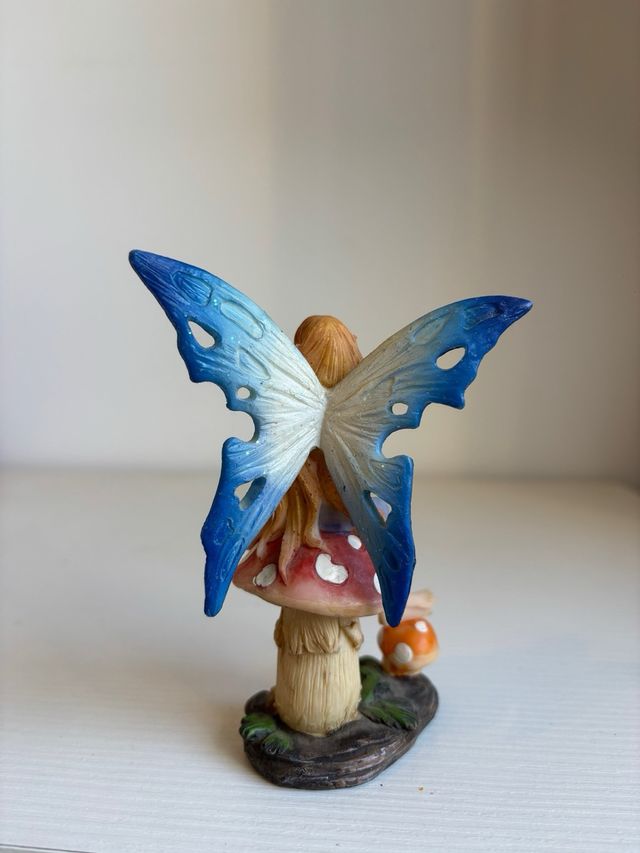 Fatina blu seduta su fungo