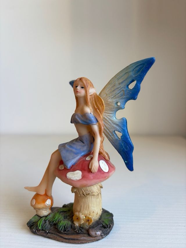 Fatina blu seduta su fungo