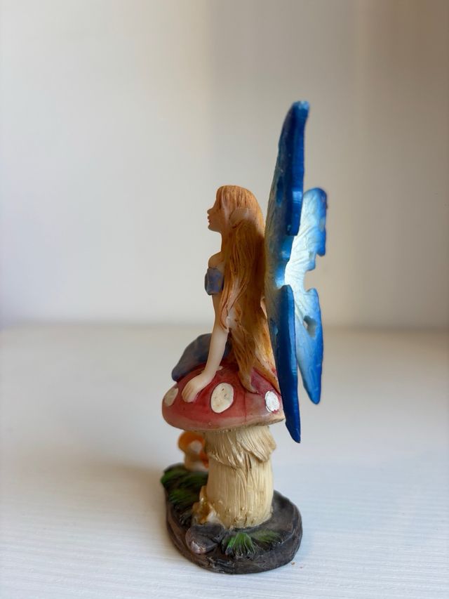 Fatina blu seduta su fungo