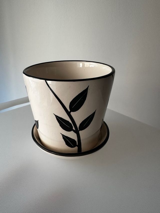 Taza cerámica decorada con hojas.