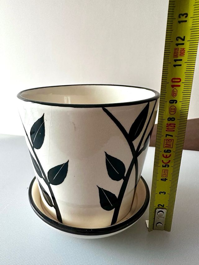Taza cerámica decorada con hojas.