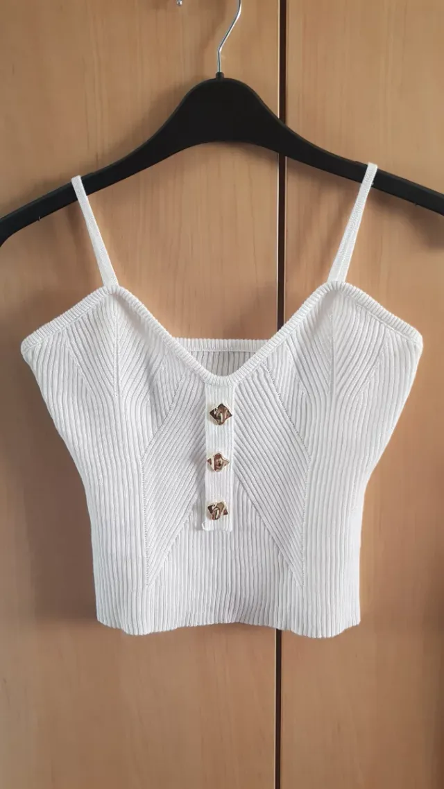 Top blanco con botones dorados