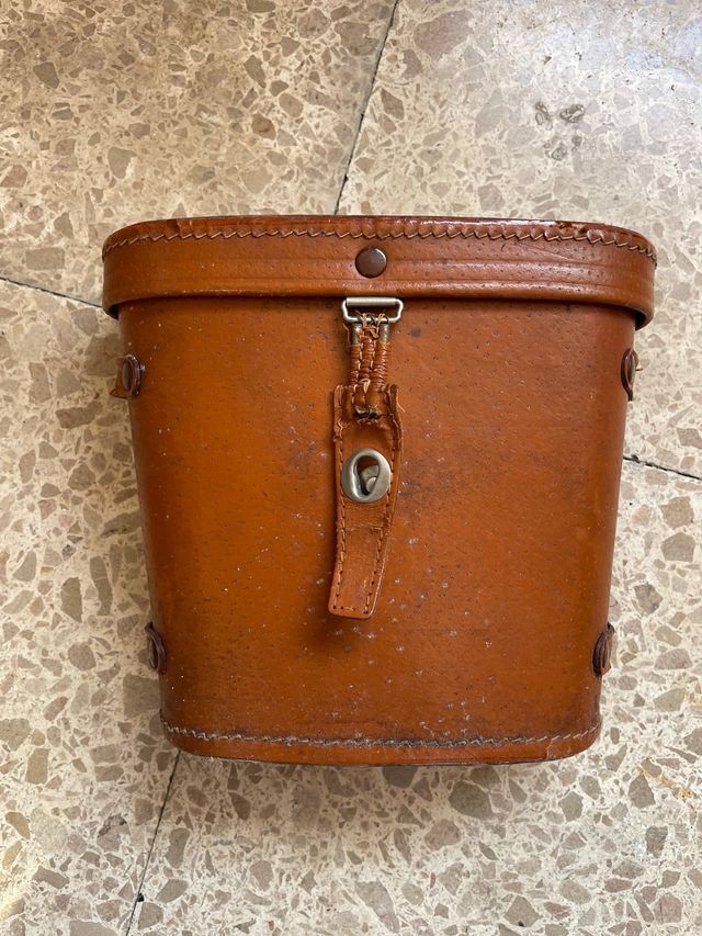 Prismáticos antiguos con funda de cuero.