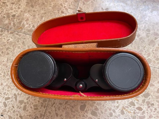 Prismáticos antiguos con funda de cuero.