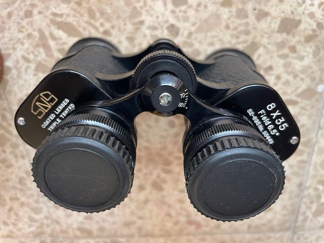 Prismáticos antiguos con funda de cuero.