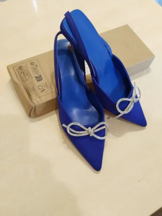 Zapatos azules de tacón dorado con lazo plateado