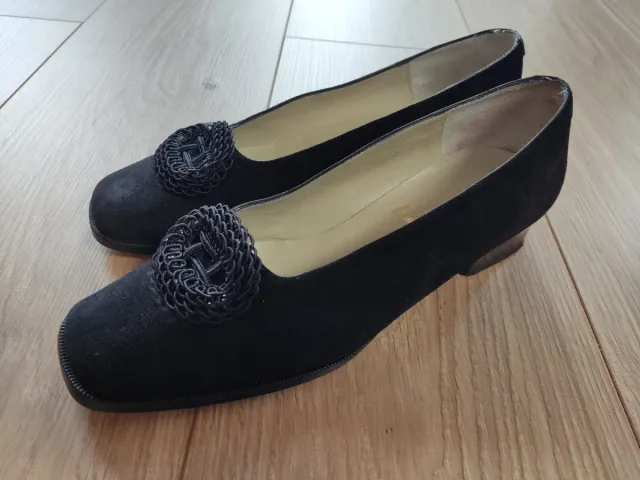 Zapatos de ante negro con adorno.