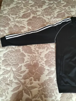 Chaqueta marca Adidas en colores negro y blanco.