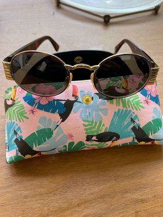 Gafas de sol ovaladas doradas y marrones versus