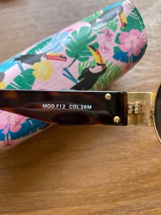 Gafas de sol ovaladas doradas y marrones versus