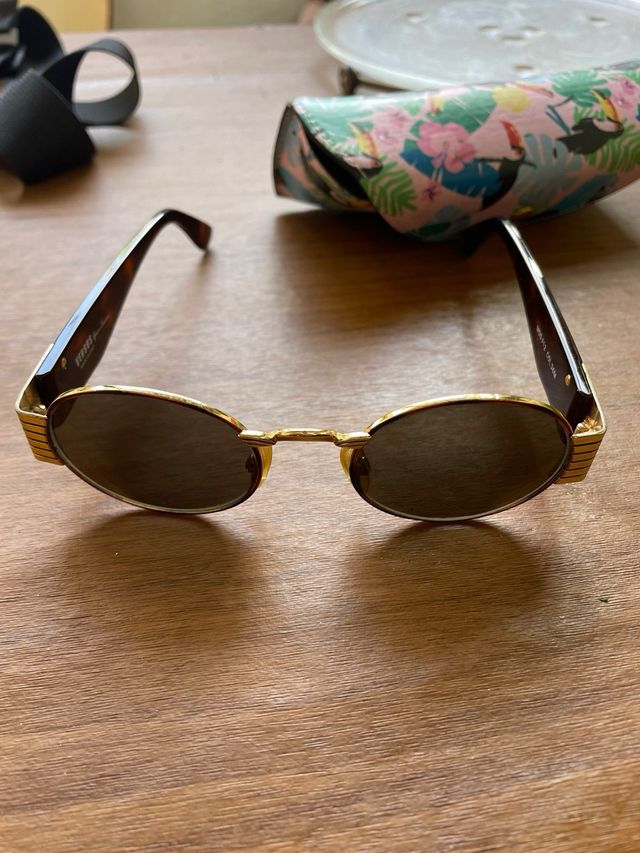 Gafas de sol ovaladas doradas y marrones versus