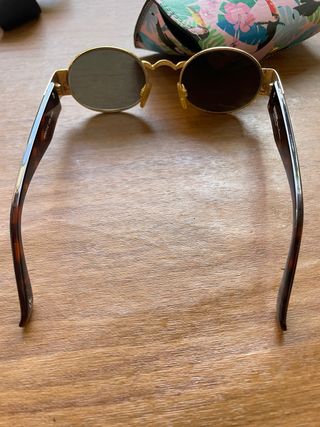 Gafas de sol ovaladas doradas y marrones versus