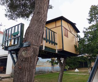 Casetta in legno per bambini con altalene