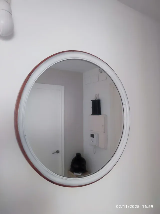 Specchio rotondo in legno e vetro.