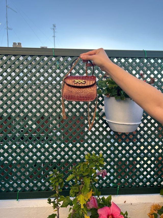 Bolso mini de mano con broche dorado