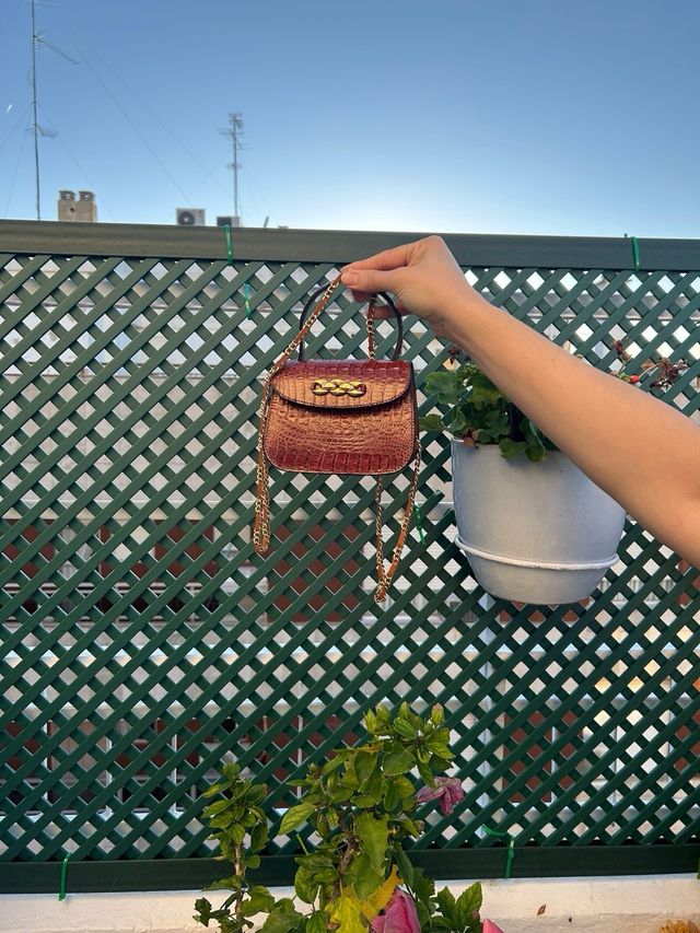 Bolso mini de mano con broche dorado