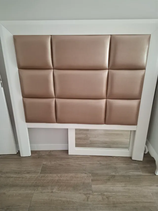 Cabecero tapizado beige, comoda y mesitas noche.