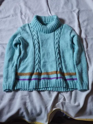 Jersey azul con cuello alto y trenzas