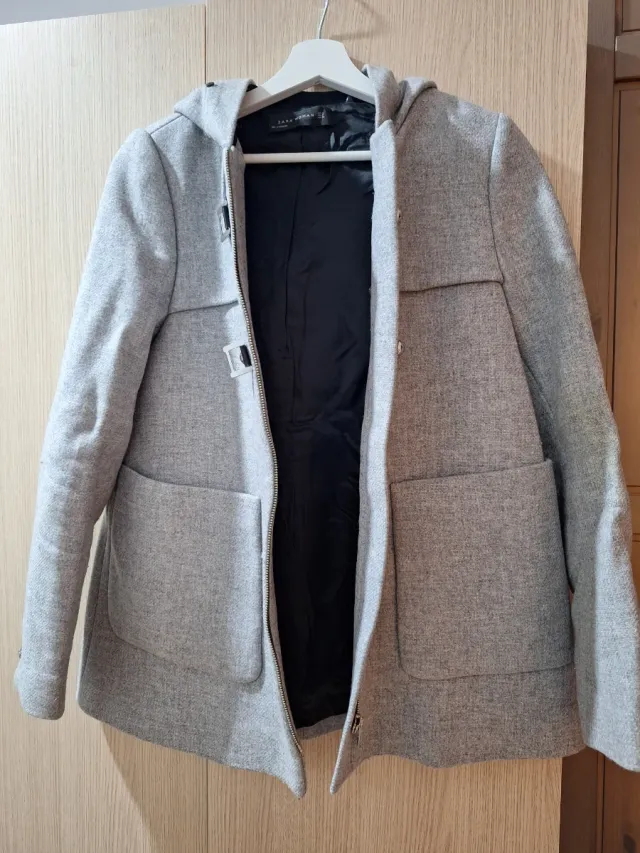 Chaqueta gris con capucha y cremallera