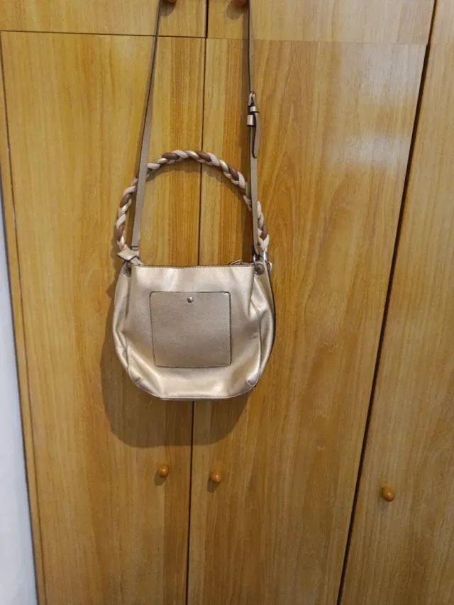 Bolso dorado con bandolera trenzada