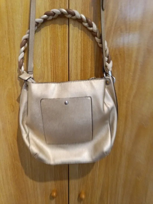 Bolso dorado con bandolera trenzada