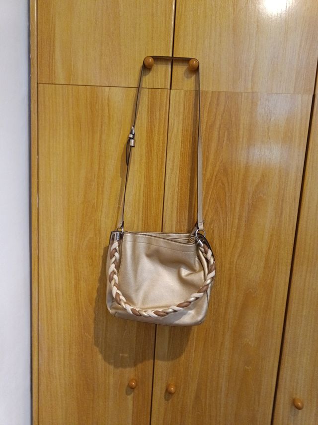 Bolso dorado con bandolera trenzada