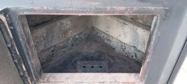 Estufa de leña negra con puerta de cristal