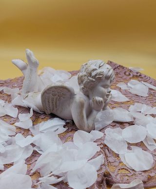 Statua angioletto sdraiato in ceramica