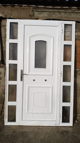 Puerta de entrada blanca con cristales