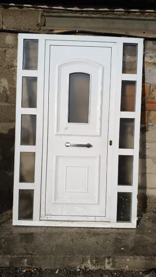 Puerta de entrada blanca con cristales