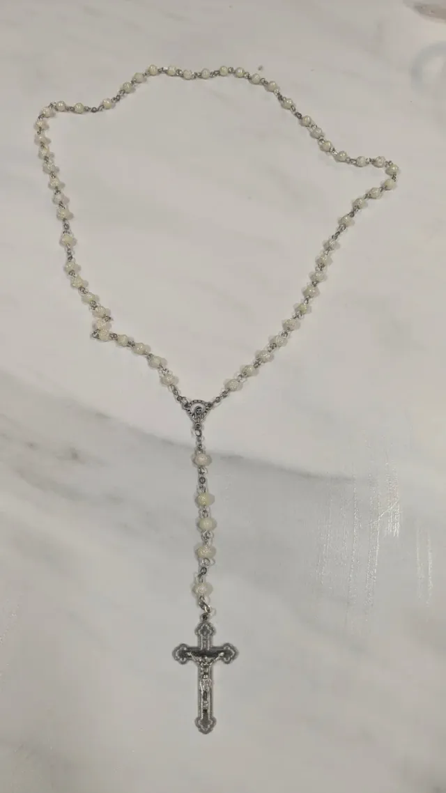 Rosario de cuentas blancas y cruz plateada