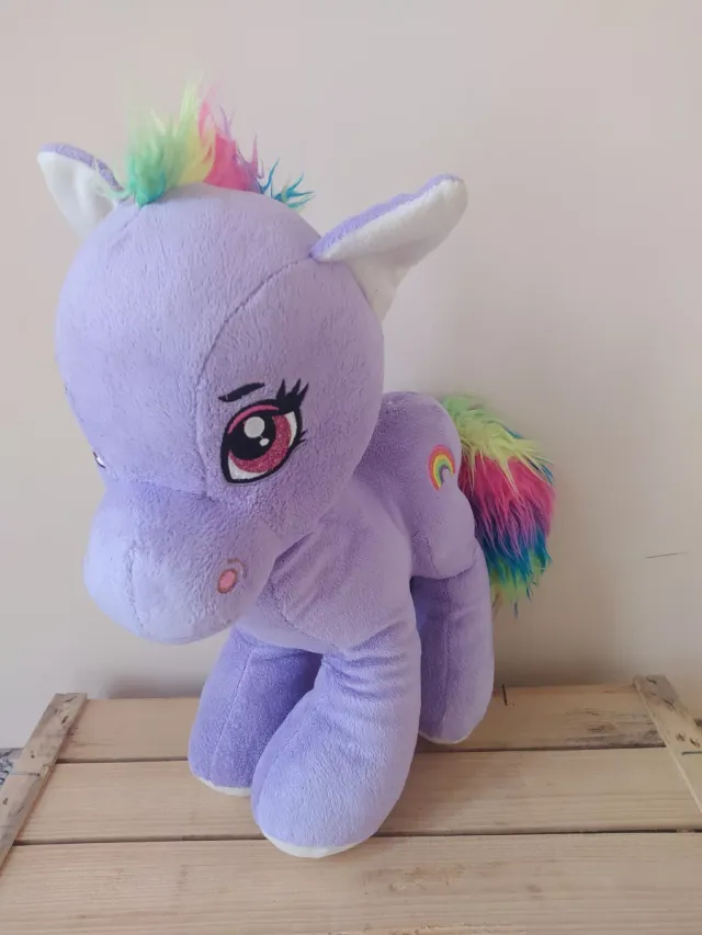 Caballito de peluche morado con arcoíris