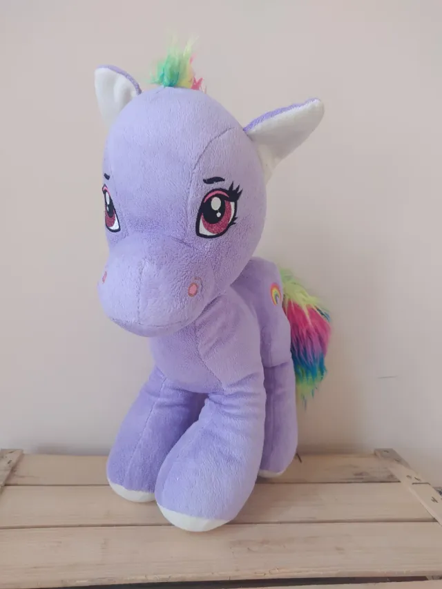 Caballito de peluche morado con arcoíris