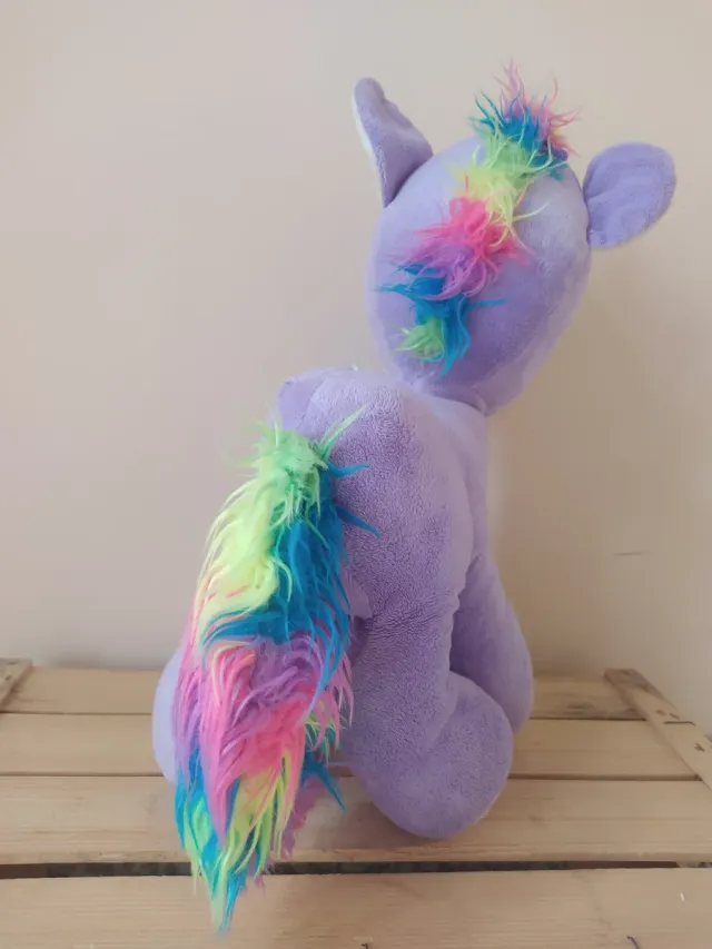 Caballito de peluche morado con arcoíris