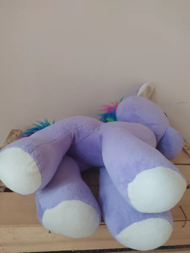 Caballito de peluche morado con arcoíris