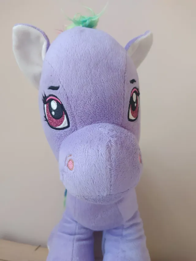 Caballito de peluche morado con arcoíris