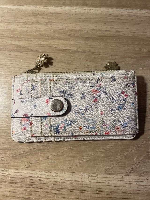Cartera floral con cremallera y broche.