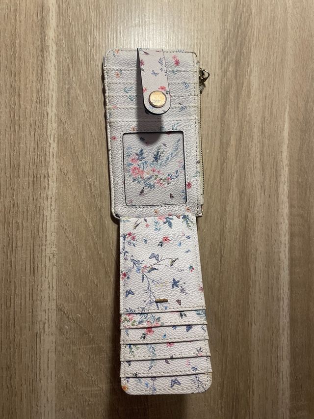 Cartera floral con cremallera y broche.