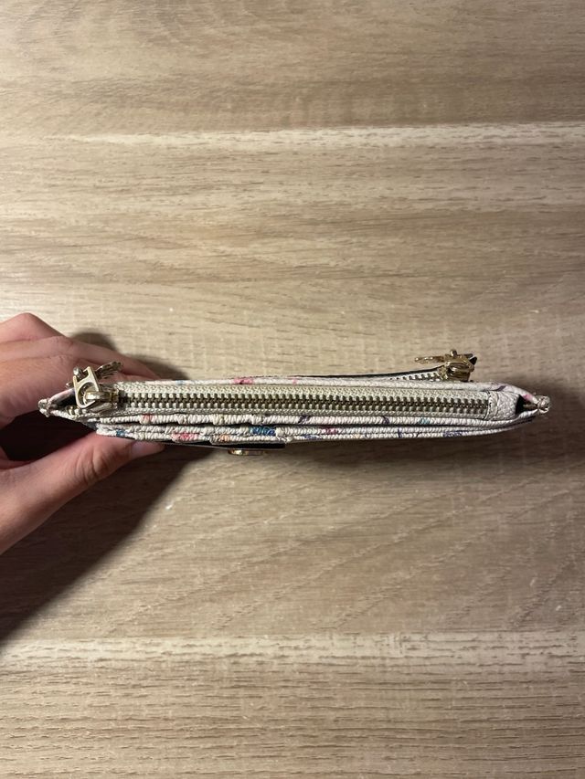 Cartera floral con cremallera y broche.