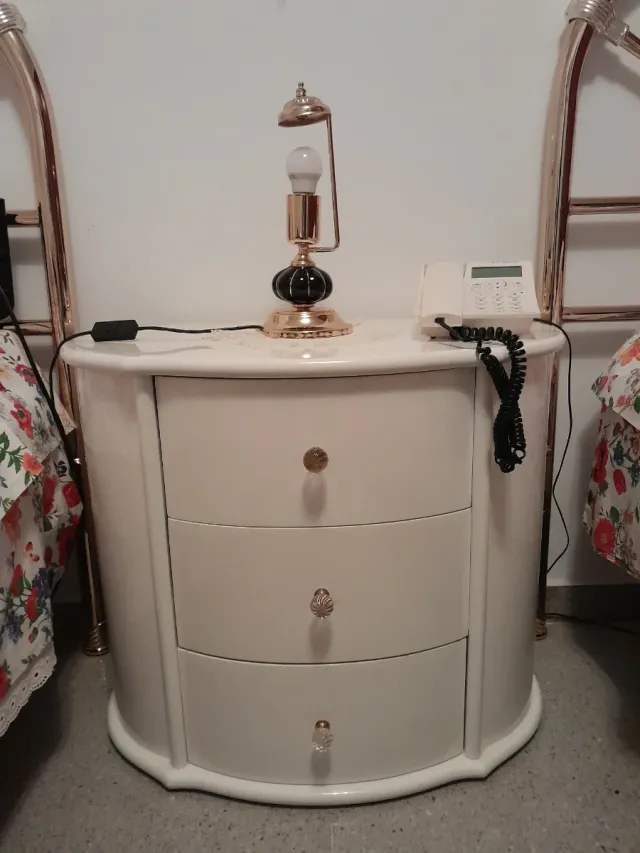 Mesita de noche blanca y dorada