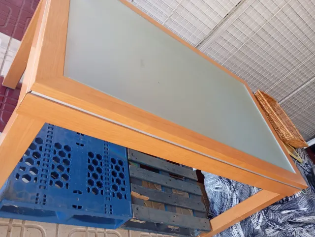 Mesa de madera con superficie de cristal