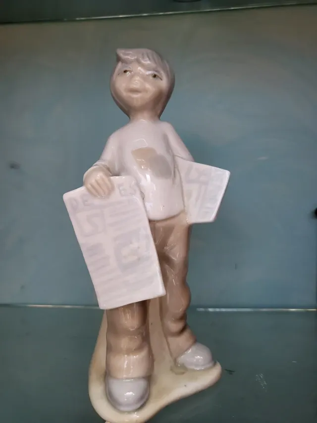 Figura de porcelana niño con periódico