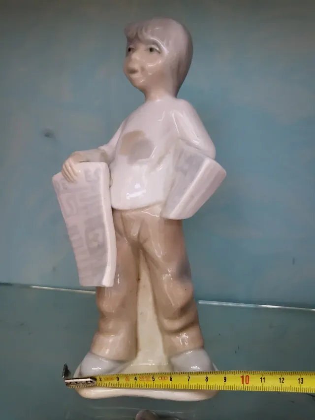 Figura de porcelana niño con periódico