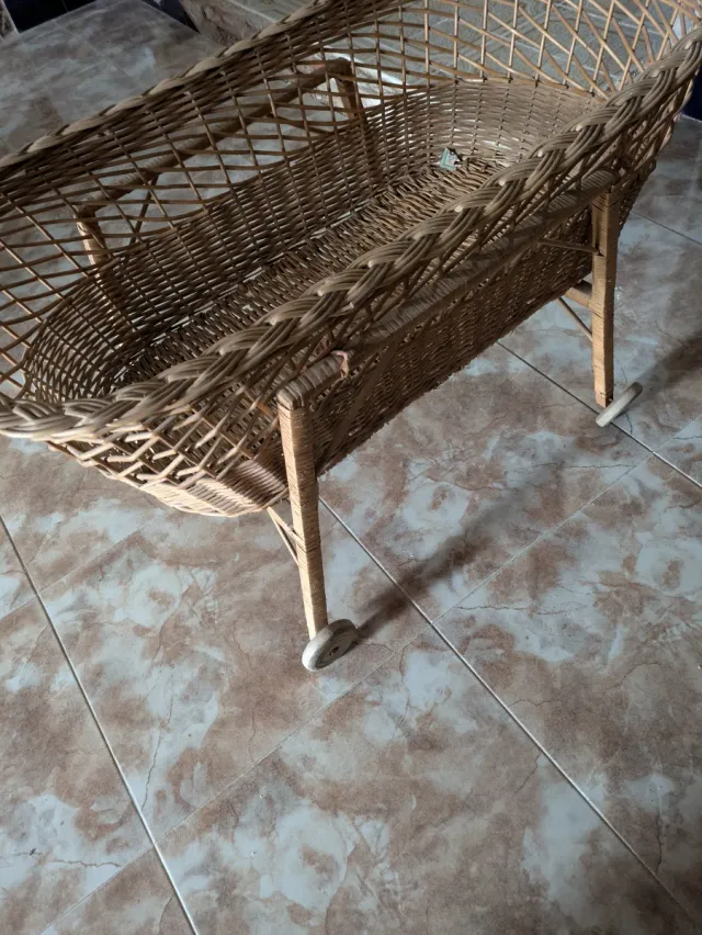 Cuna antigua mimbre y madera con ruedas de madera