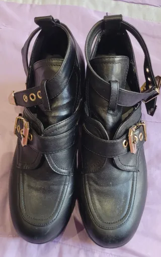 Botas negras con hebillas doradas